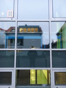 man-reflecting-glass-windows-building